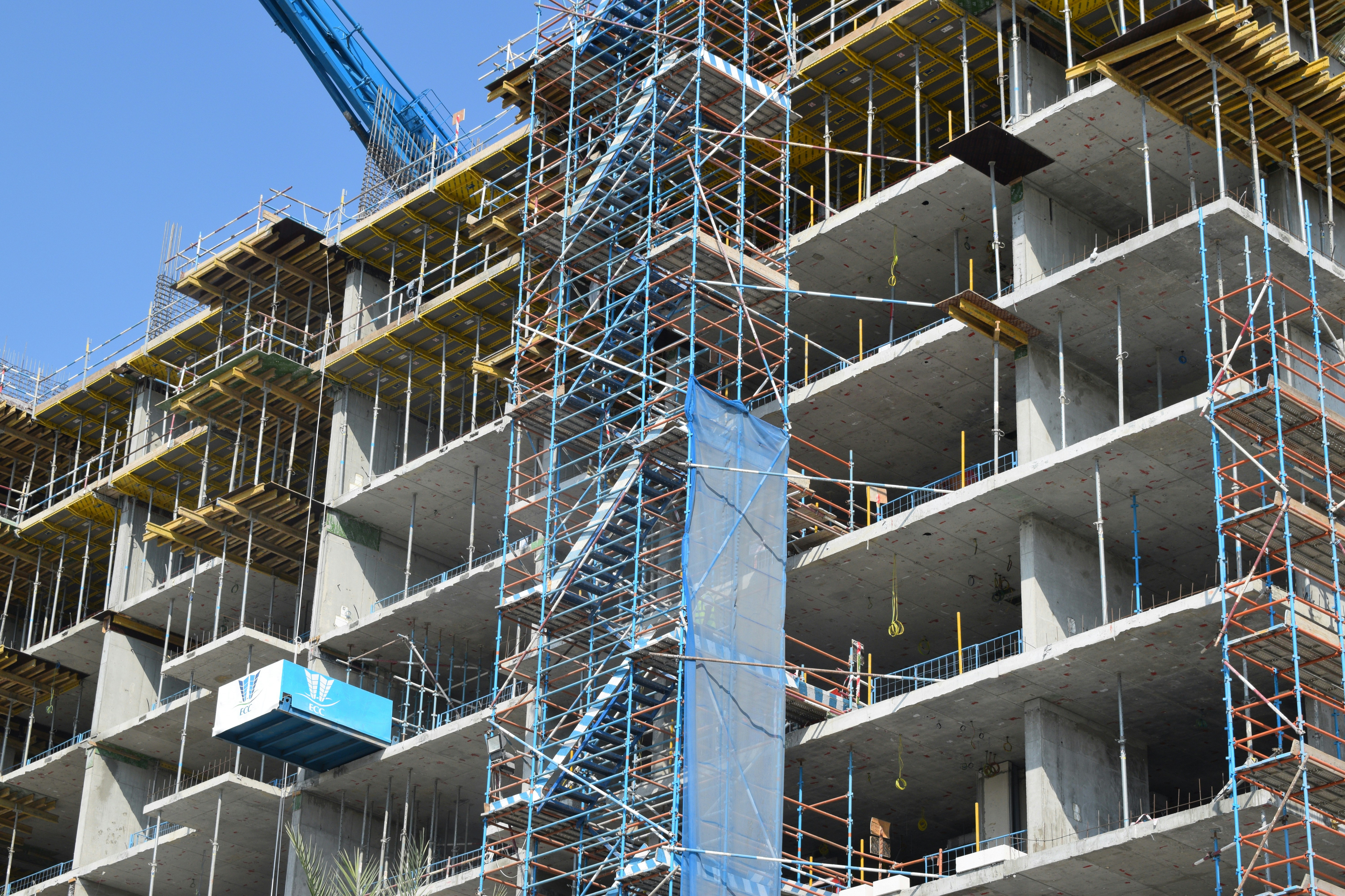 image shows a construction project underway. A concrete building with scaffolding